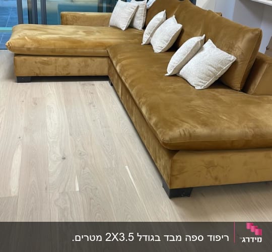 ספה חומה עם כריות לבנות על רצפת עץ בהירה